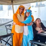 Coppia di ragazzi a figura intera durante il Carnevale 2026 di ELO Epilessia Lombardia ETS, lei in costume da unicorno e lui in costume arancione