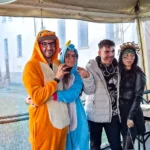Due coppie che si abbracciano durante il Carnevale 2026 di ELO Epilessia Lombardia ETS, una con ragazza in costume da unicorno e ragazzo in costume arancione, l’altra con ragazza con viso truccato e corona decorativa