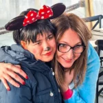 Due ragazze si abbracciano durante il Carnevale 2026 di ELO Epilessia Lombardia ETS, una travestita da Minnie con orecchie e naso truccato