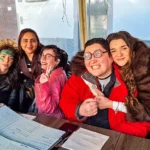 Gruppo di ragazzi seduti dietro a un tavolo sorridenti durante il Carnevale 2026 di ELO Epilessia Lombardia ETS