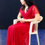 Attrice in abito rosso – spettacolo "Interviste Impossibili" ELO ETS giugno 2026