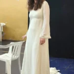 Attrice in abito bianco sul palco – spettacolo finale ELO ETS e Youmani ODV 2026