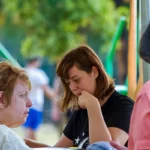 Chiacchiere all'aria aperta tra partecipanti e volontari – vacanze estive ELO 2026